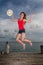 Young woman jumping at the pier