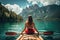 Young woman kayaking on lake braies in south tyrol italy, Female kayaking on a mountain lake, rear view, no face revealed, natural