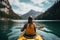 Young woman kayaking on lake in mountains. Adventure and travel concept, Female kayaking on a mountain lake, rear view, no face