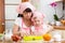 Young woman and kid daughter making berry fruit cake