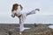 Young Woman in Kimono practicing karate on river coast