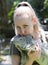The young woman kisses an iguana, holds her on hands