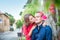 Young woman kissing a man on cheek. Fall in love romantic married couple in bright clothes on the street with blooming trees. Fami