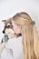 Young woman kissing a puppy Finnish Lapphund dog