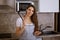 Young woman in kitchen with ladle in hand smiling