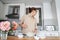 Young woman in the kitchen preparing dessert and watching the recipe on the laptop on the Internet, cooking at home, hobbies and