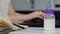 Young woman in kitchen during quarantine. Female hands typing on laptop`s keyboard and writing notes in notebook