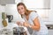 Young woman in the kitchen with thump up