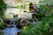 Young woman kneeling by stream catching water in hands