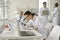 Young woman lab worker working with microscope making notes on clipboard