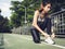 Young woman lace up her shoe ready to workout on exercising in the park with warm light sunshine in morning.