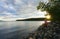 Young woman on lakeshore enjoying sunset