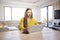 Young woman with laptop sitting at desk and workin at home