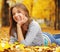 Young Woman Laying Down On The Ground In Autumn Park, beauty girl in fall forest