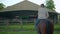 Young woman learn riding a horse. Brawn horse walking in an arena with female rider on its back.