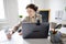 Young woman is learning language with laptop computer, camcorder and headphone online at home. Student is having video conference