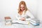 Young woman learning at table with a lot of books