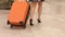 Young woman legs in high heel shoes walking with wheeled suitcase, tourism