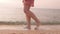 Young woman legs walking on beach. Female relax strolling on beach near sea at sunrise. Lifestyle women travel on beach concept.