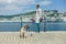 Young woman with Leonberger puppy standing by water