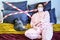 A young woman lies in bed with a cat quarantined from coronavirus. Girl in a homemade medical mask lies with a cat during a