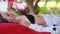 Young woman lies in spa saloon relaxing on the tropical beach. Close up of massage therapist doing hands thai oil