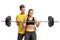 Young woman lifting a barbell with the help of a fitness coach