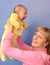 The young woman lifts on the baby\'s hands