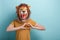 Young woman in lion mask shows love heart affection hand gesture, isolated