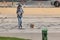 Young woman listening music with earphones and crossing the road with his dog