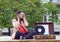 Young woman listening to music in a park. Portrait of girl feeling good with songs on old stereo vinyl system