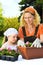 Young woman and little girl gardening in spring, planting flower seedlings, smiling mother and her happy child working in garden