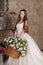 Young woman in long dress holds basket of flowers