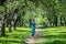 Young woman in a long dress in a wonderful spring flowering orch