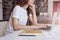 Young woman long hair analyst working at co-working office on laptop, bookshelf behind. Businesswoman learning alone in library