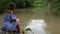 Young woman look at monitor lizard in pond