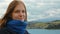 Young Woman Looking at Camera and Smiling at the Background of Lake and Mountain