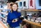 Young woman looking for food bowl for dog in pet store