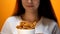 Young woman looking at fried chicken wings, high calorie food and health risks