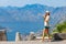 Young woman looking at Kotor bay in Montenegro through binoculars at view spot on serpantine road