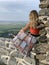 A young woman looking at the landscape from a lookout on the hill