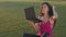 Young woman looking in laptop as in in mirror. Asian woman sitting on grass