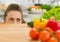 Young woman looking out from cutting board