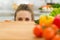 Young woman looking out from cutting board