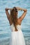 Young woman looking at sea water in summer holiday taking ponytail on her hair enjoying vacation relaxed