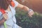 Young woman looking at smart watches on her wrist, while trekking and walking along mountain meadows