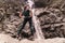 Young woman looking at splashing waterfall in rocky mountain. Caucasian Traveler standing before water stream