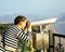 young woman looking through telescope at sea viewpoint in Atatur