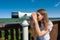 Young woman looking through tourist sightseeing binoculars