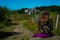 Young woman looking towards Aubrac village ,a stage on the compostelle walk or saint James way, with wild flowers in foreground